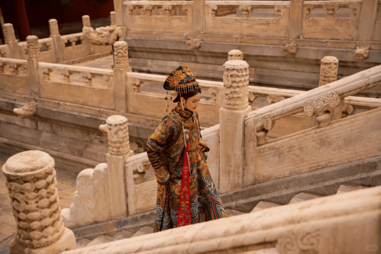 Woman in ornate Qing-style dress walking along stone steps in a historic palace courtyard.
