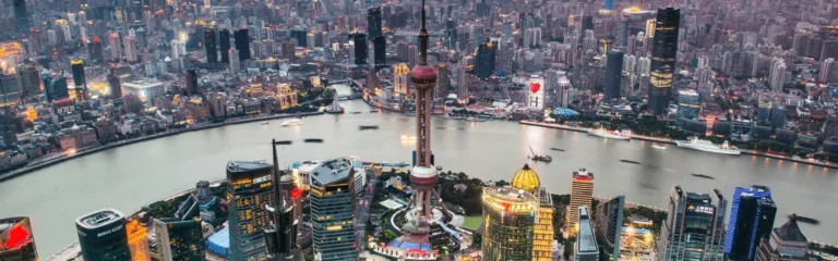 Aerial view of Shanghai skyline with the Oriental Pearl Tower and the Bund along the Huangpu River at dusk