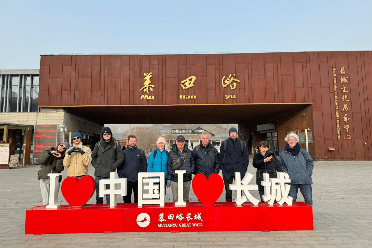A group of visitors standing behind an “I Love China” sign at the entrance of the Mutianyu Great Wall