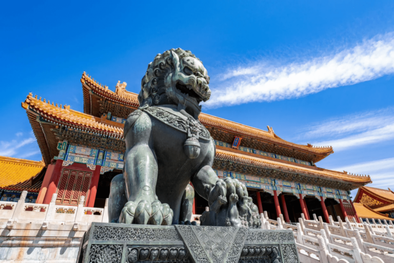 Bronze guardian lion statue in front of the Forbidden City palace.