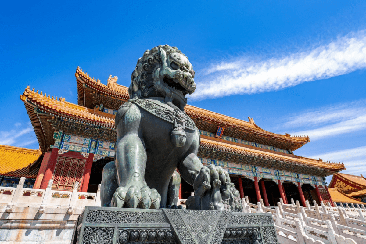 Bronze guardian lion statue in front of the Forbidden City palace.