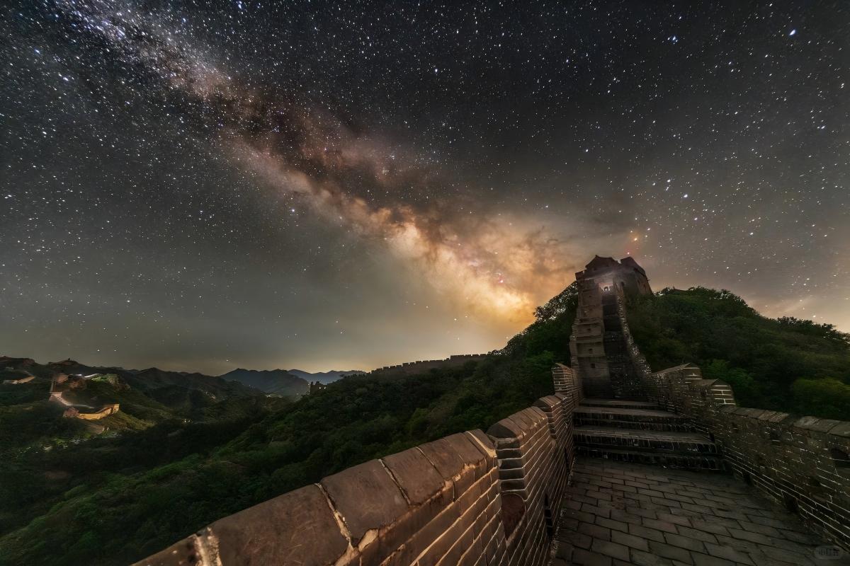 The Great Wall under a bright Milky Way and starry night sky.