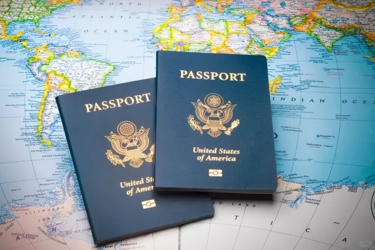 Two U.S. passports placed on a colorful world map.