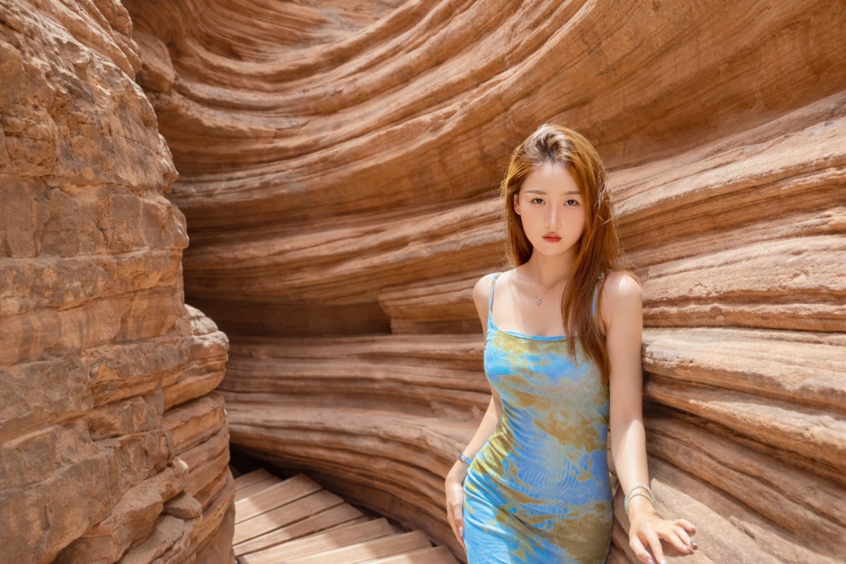 Woman standing in a narrow red sandstone canyon passage.