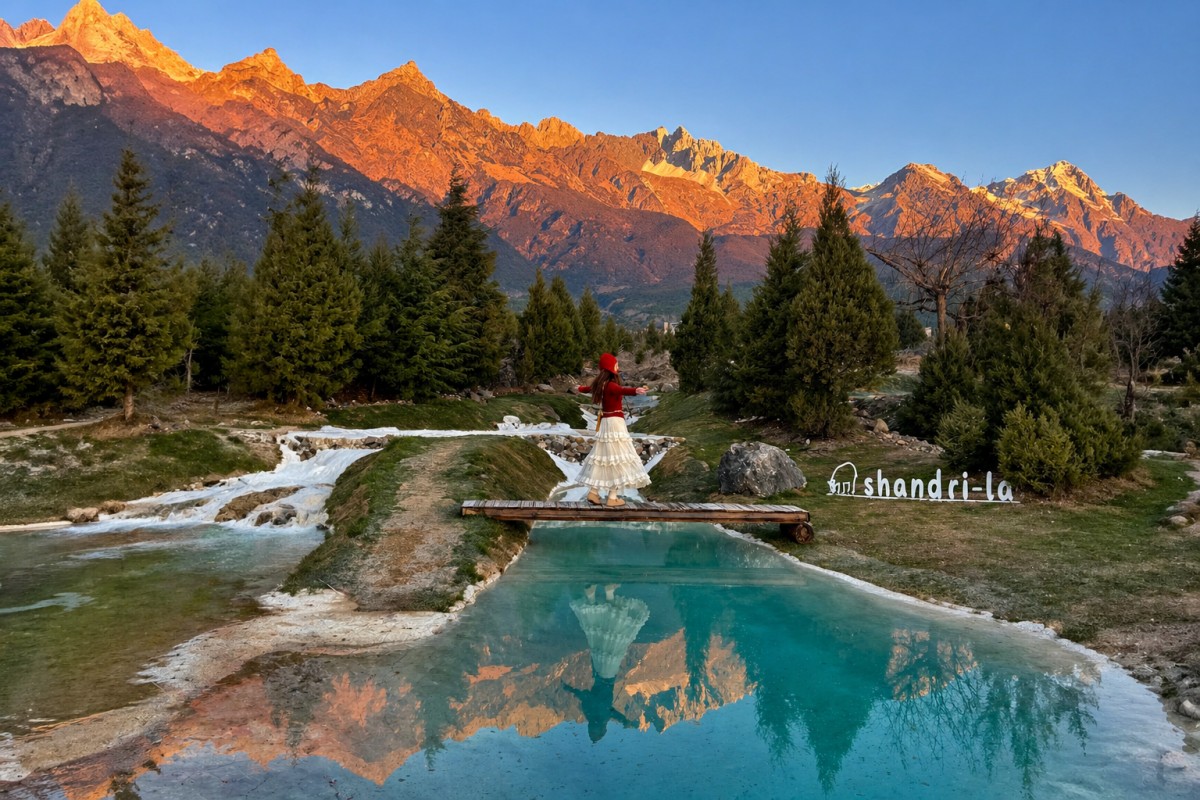 Woman on bridge with snowy mountains reflected in clear water