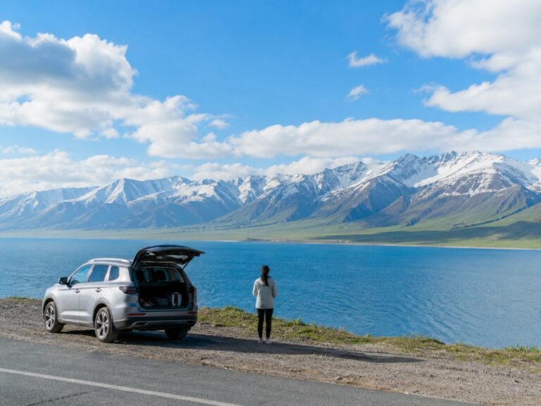 SUV parked by blue lake with snowy mountains and traveler enjoying the view
