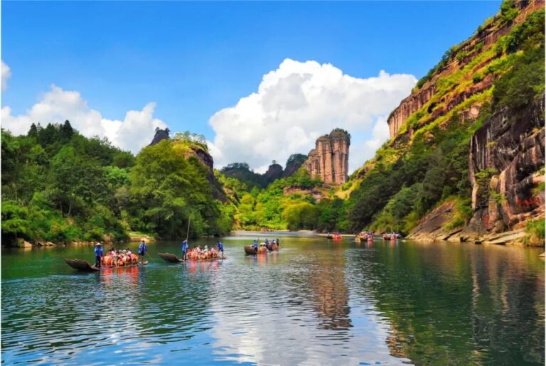 Bamboo rafting on the river surrounded by Wuyi Mountain cliffs and lush forest