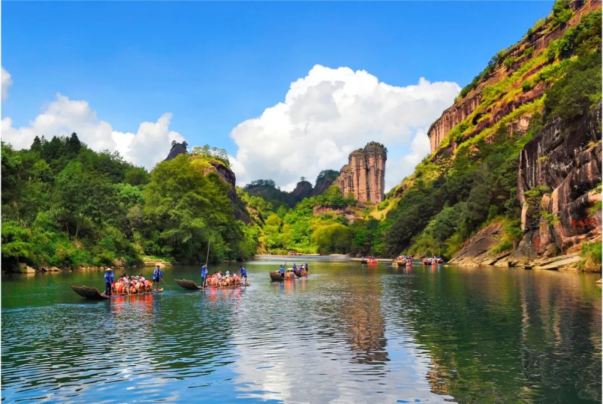 Bamboo rafting on the river surrounded by Wuyi Mountain cliffs and lush forest