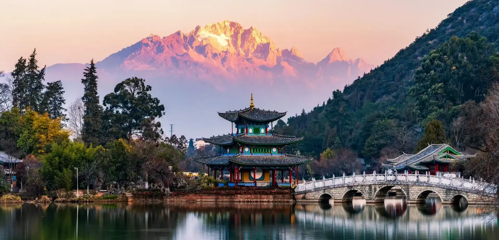 Traditional pavilion, stone bridge and Jade Dragon Snow Mountain near Lijiang, Yunnan