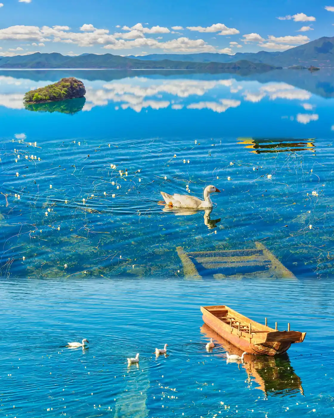 Clear water, mountains and a wooden boat at Lugu Lake in Yunnan