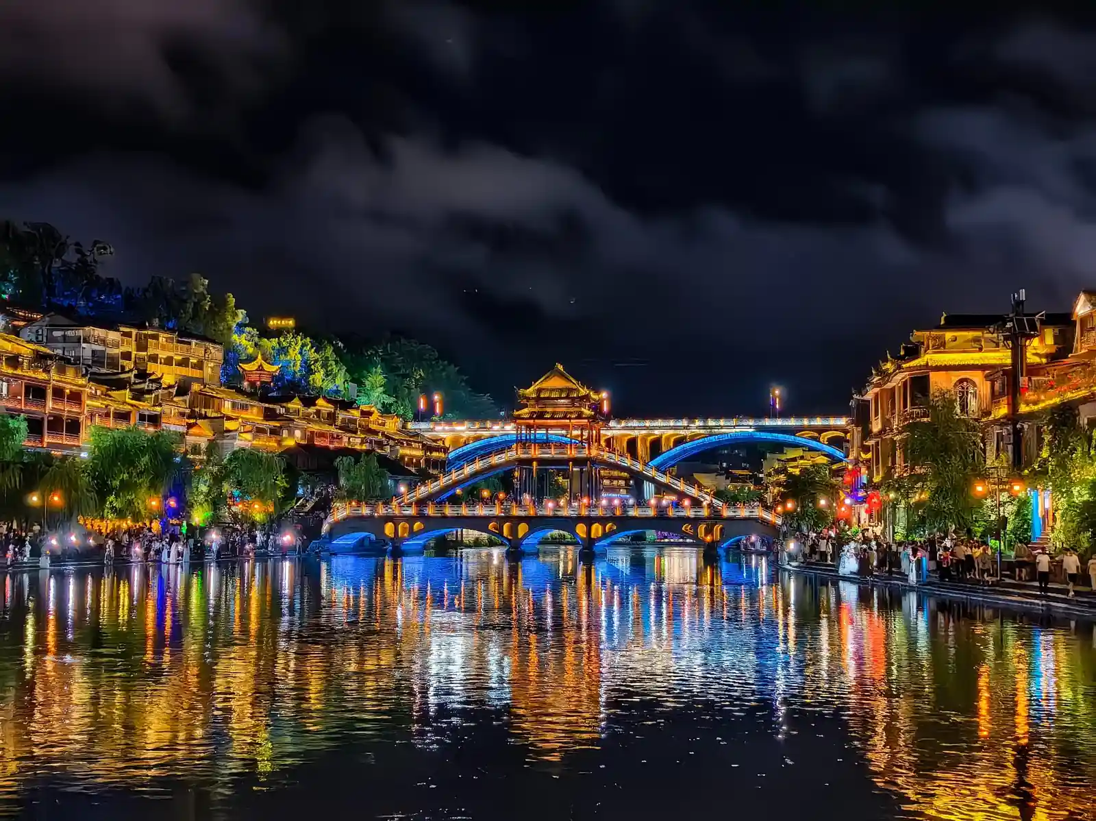 Fenghuang Ancient Town illuminated along the river at night