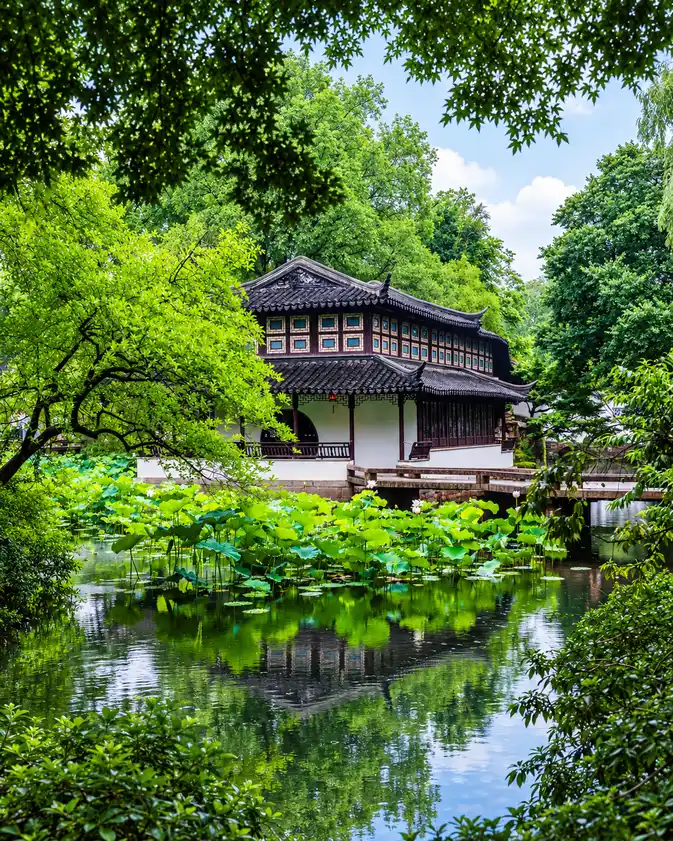 A pavilion in a classical Chinese garden by a lotus pond in summer