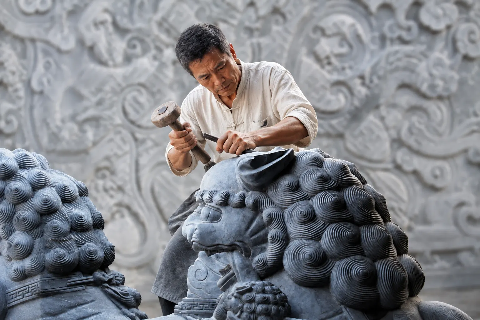 Traditional stone carving craftsman demonstrating a Huizhou craft