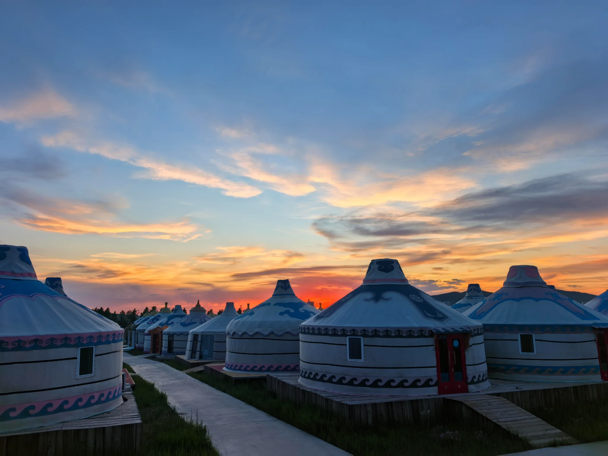 Traditional Mongolian yurt camp on the grassland at sunset
